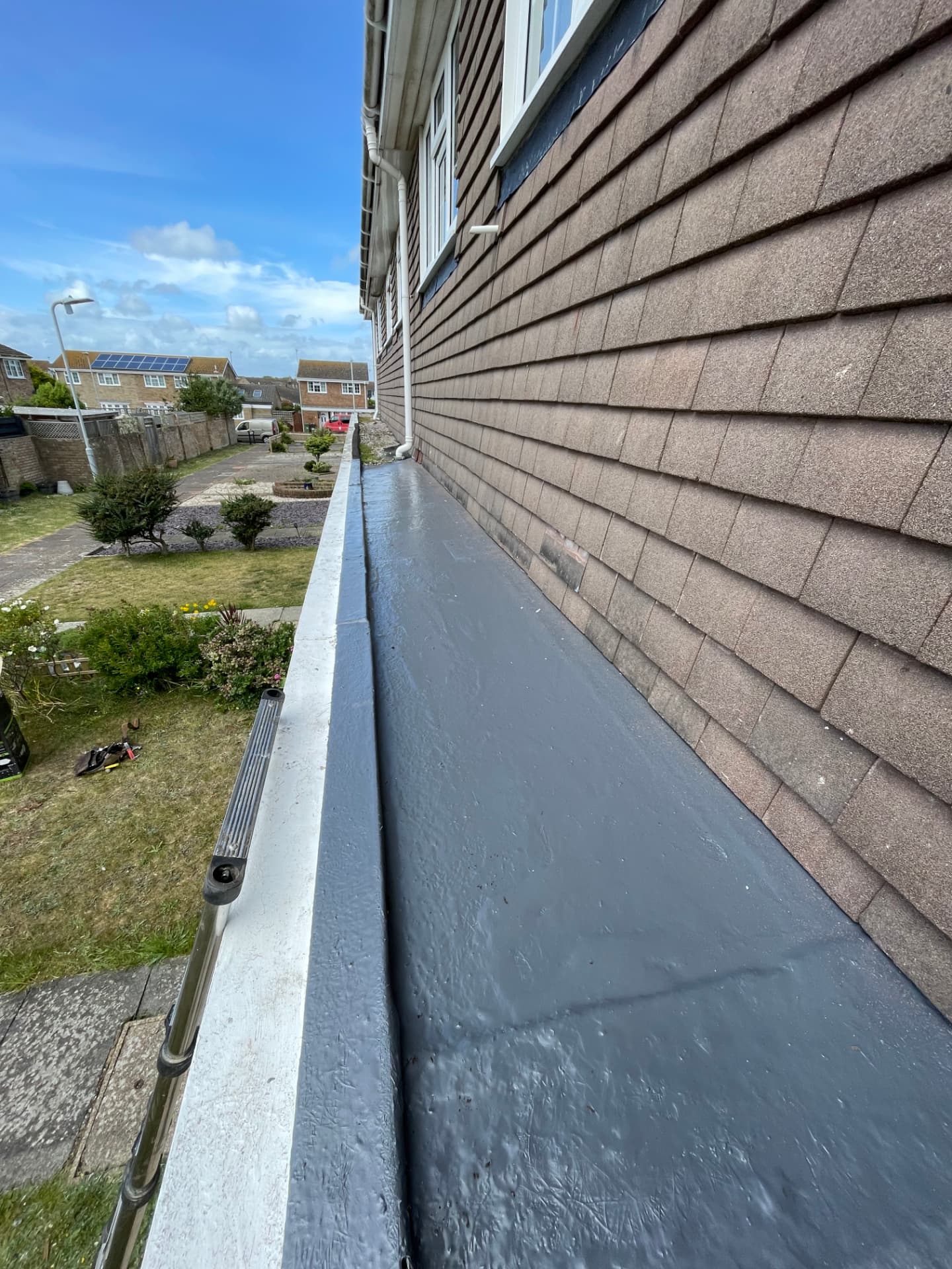 Narrow flat roof strip renewed along the side of a house