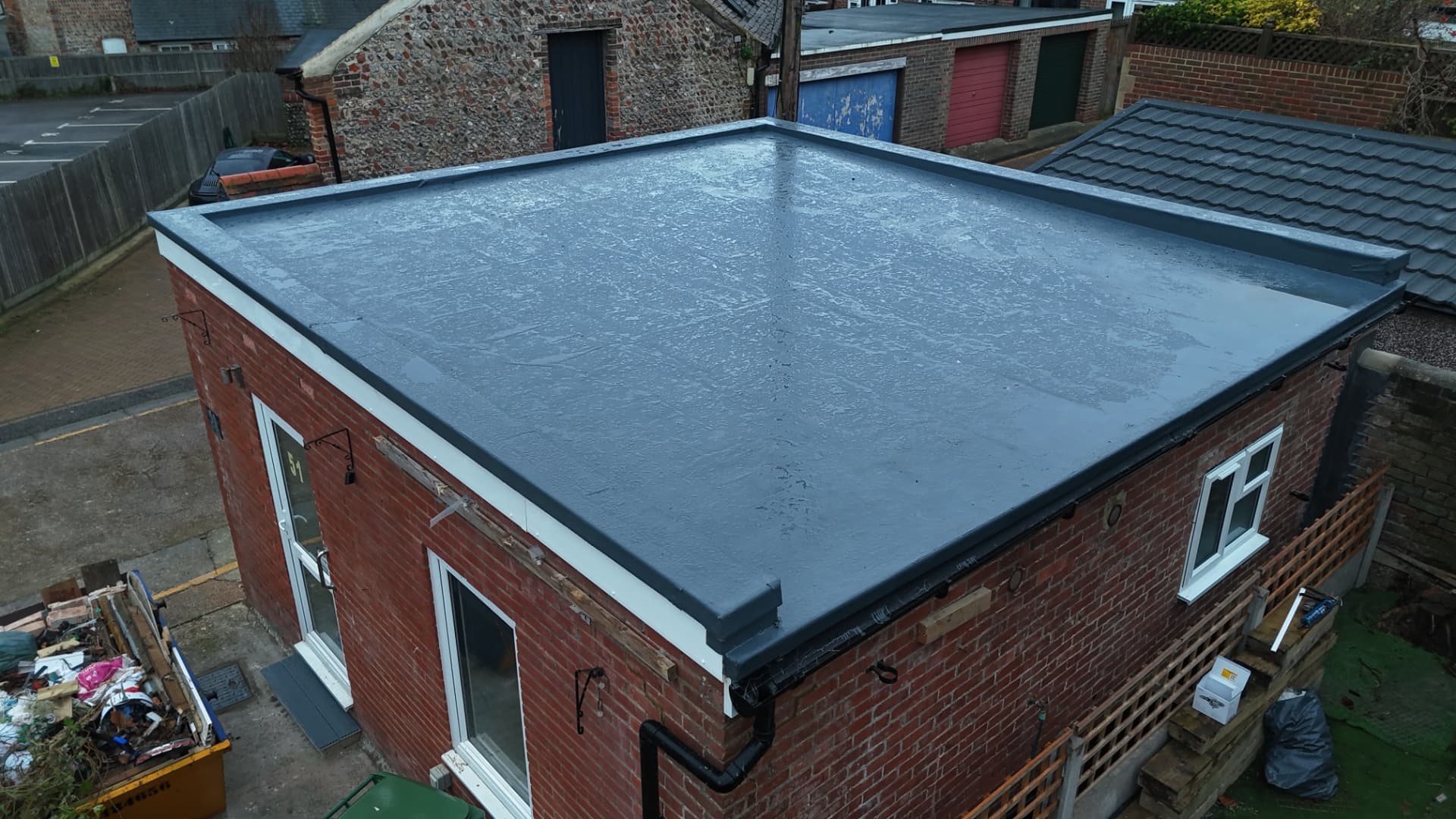 Aerial view of a new GRP flat roof on a brick building completed by JP Roofing